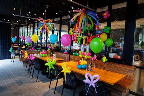 Colourful restaurant birthday styling with helium balloons, balloon flowers and ceiling firework details