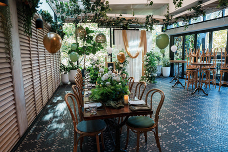 Green and white floral birthday styling with helium balloons at a North Sydney restaurant