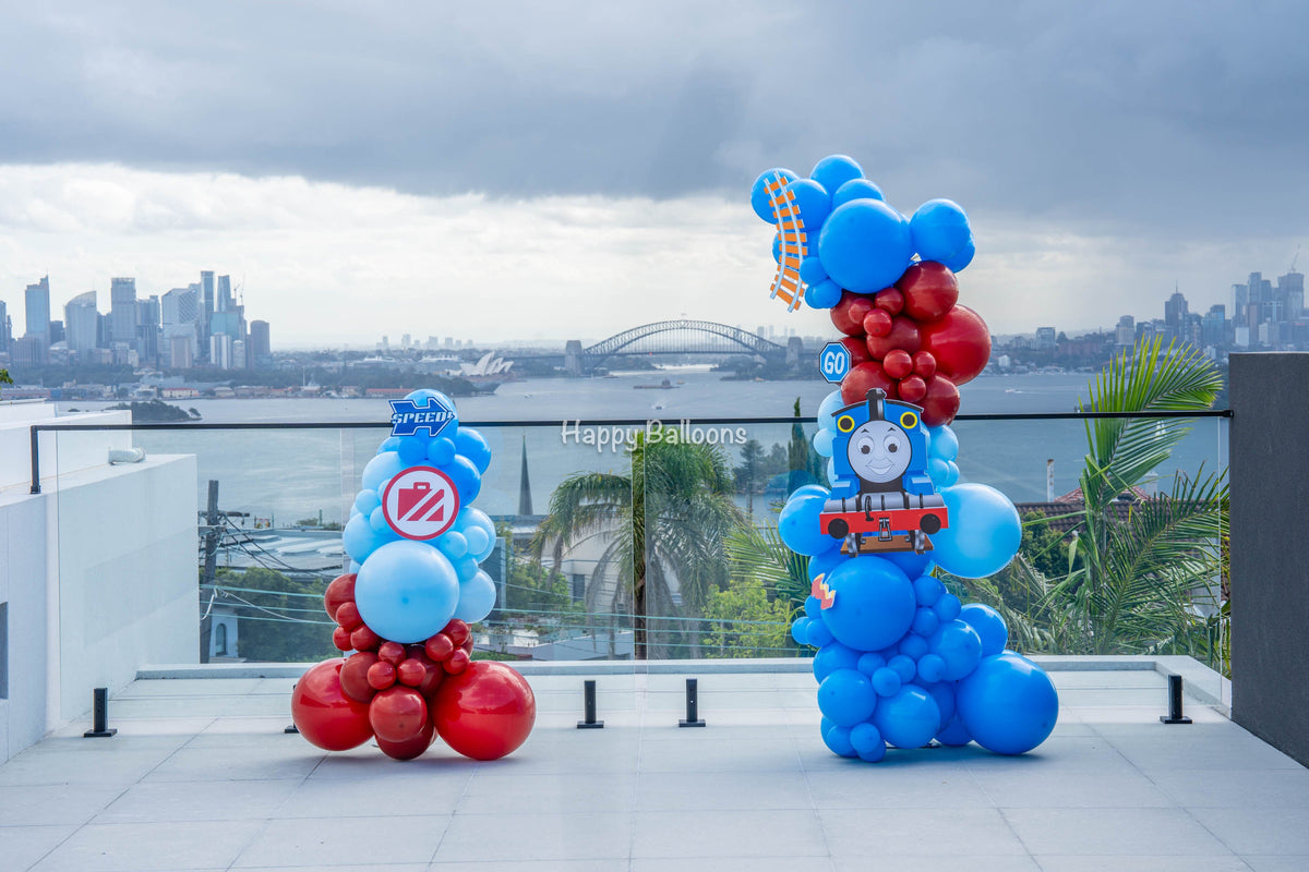 Outdoor red-and-blue balloon columns overlooking Sydney Harbour in Vaucluse